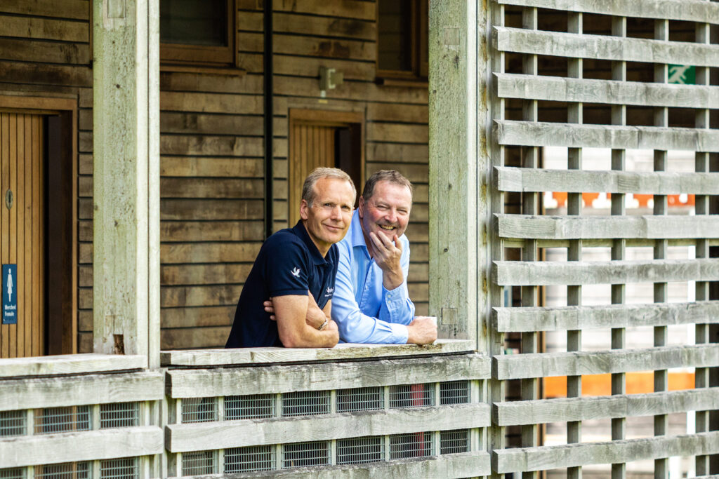 Two men side by side overlooking a balcony